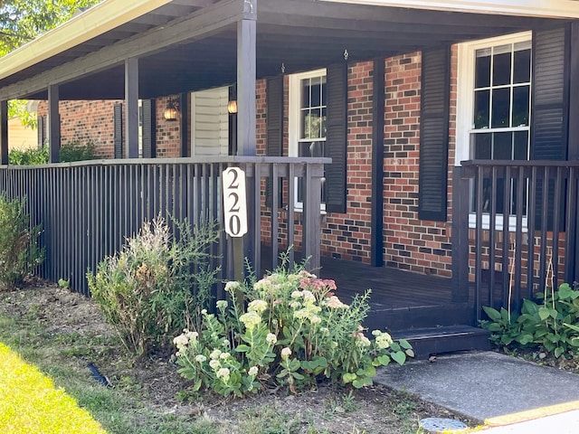 view of exterior entry featuring covered porch