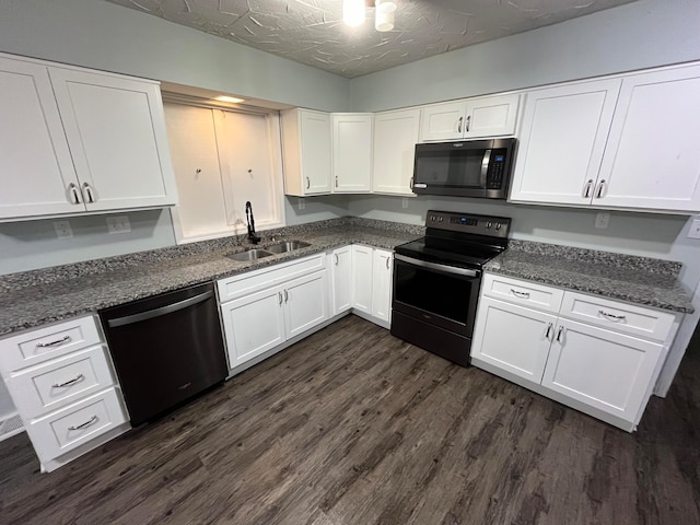 kitchen featuring sink, dark hardwood / wood-style floors, appliances with stainless steel finishes, and white cabinets