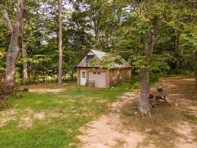 view of yard featuring a garage and an outbuilding