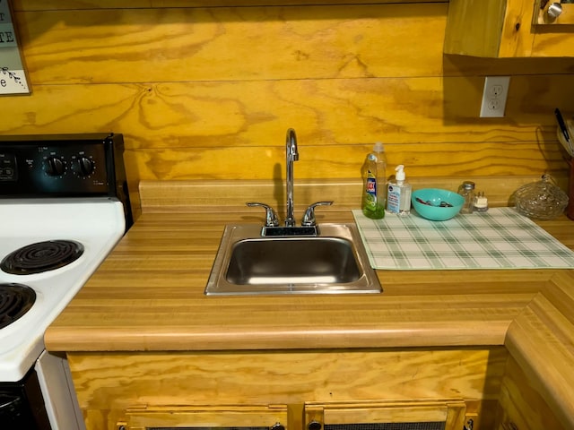 kitchen with sink, electric stove, and tile countertops