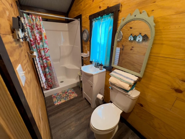 bathroom featuring vanity, wood walls, curtained shower, and toilet