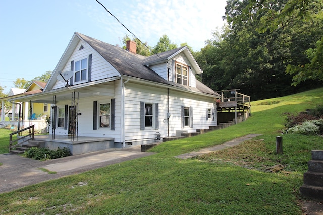 view of side of home with a porch and a yard