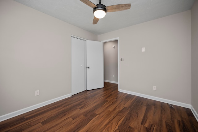 unfurnished bedroom featuring dark wood-type flooring, a closet, ceiling fan, and a textured ceiling