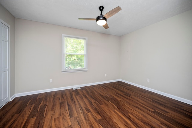 spare room with ceiling fan and dark hardwood / wood-style floors