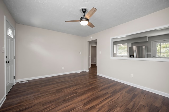 empty room featuring ceiling fan, dark hardwood / wood-style floors, and a textured ceiling