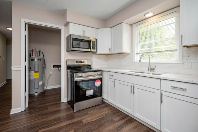 kitchen featuring sink, appliances with stainless steel finishes, dark hardwood / wood-style flooring, and water heater