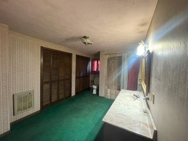 interior space featuring dark colored carpet, a textured ceiling, and sink