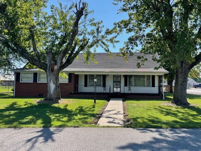 single story home with a front lawn and covered porch