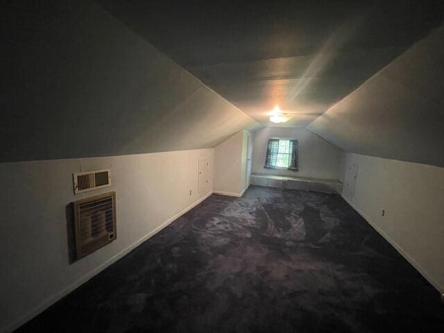 additional living space featuring vaulted ceiling and carpet floors