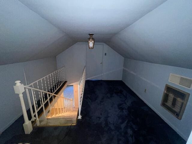 bonus room featuring lofted ceiling and dark carpet