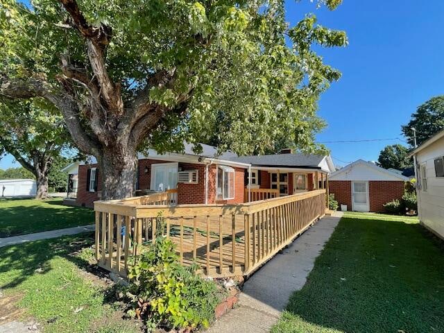 ranch-style home with a deck and a front yard