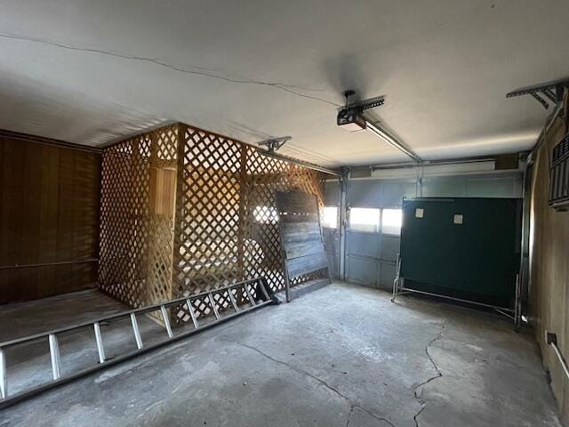 garage featuring a garage door opener and wooden walls