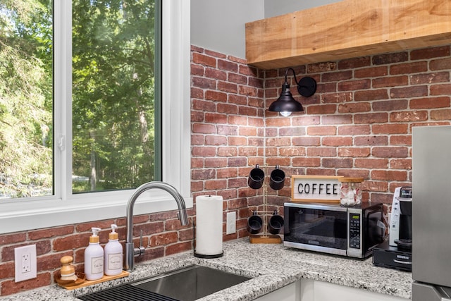 interior details featuring sink and light stone countertops