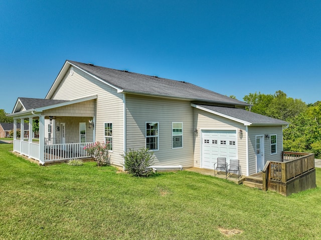 rear view of house with a lawn and a garage