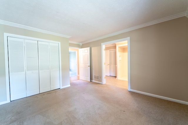 unfurnished bedroom with a closet, light colored carpet, crown molding, and a textured ceiling