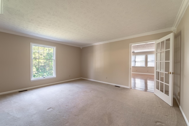 carpeted spare room with french doors, ornamental molding, and a textured ceiling