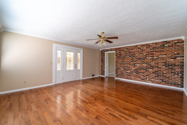 unfurnished room featuring brick wall, ceiling fan, ornamental molding, and wood-type flooring