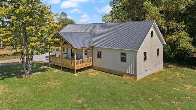 exterior space with crawl space, a lawn, a deck, and metal roof