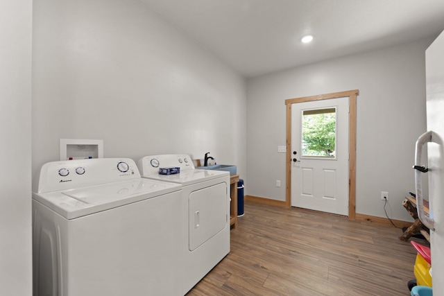 laundry area featuring laundry area, light wood finished floors, washing machine and dryer, a sink, and recessed lighting