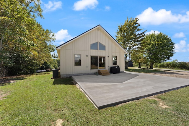 back of house featuring entry steps, a yard, and a patio area