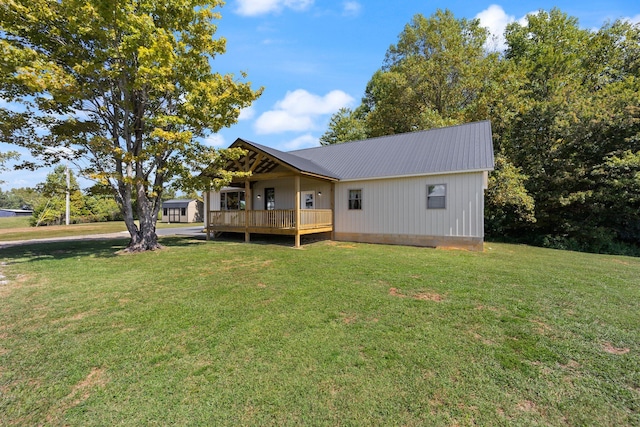 exterior space featuring metal roof, a lawn, and a wooden deck