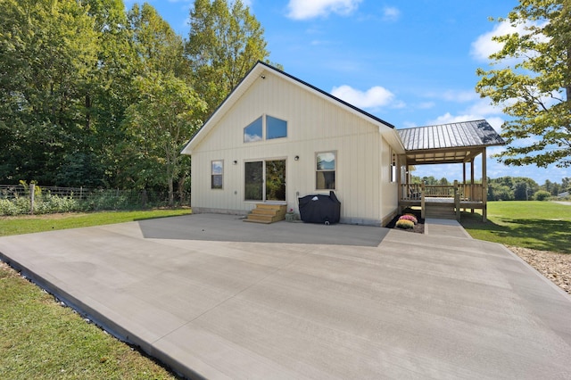 back of property featuring fence, metal roof, a patio, and a yard