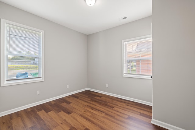 spare room featuring dark hardwood / wood-style flooring and plenty of natural light