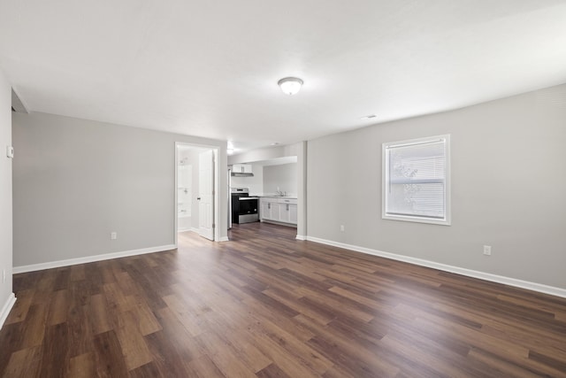 unfurnished living room with sink and dark hardwood / wood-style floors