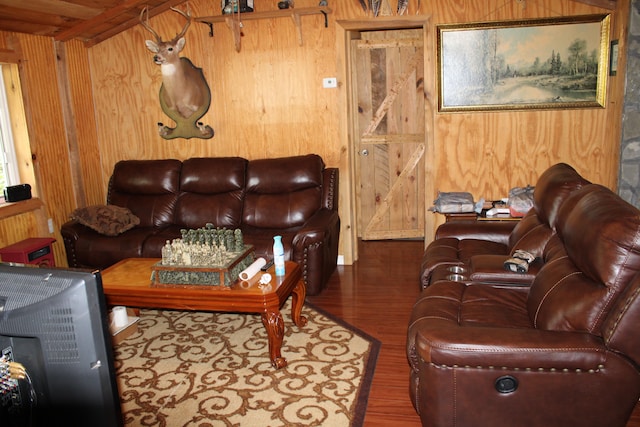 living room featuring wood walls, hardwood / wood-style floors, and beam ceiling