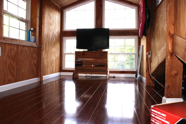 unfurnished living room with wood walls and dark hardwood / wood-style floors