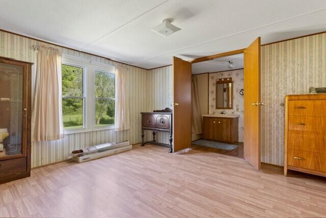 unfurnished bedroom featuring light hardwood / wood-style flooring and connected bathroom