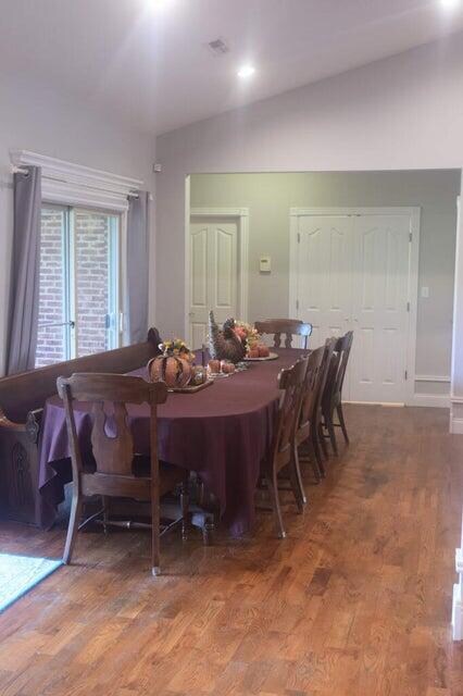 dining area featuring dark wood-type flooring and vaulted ceiling