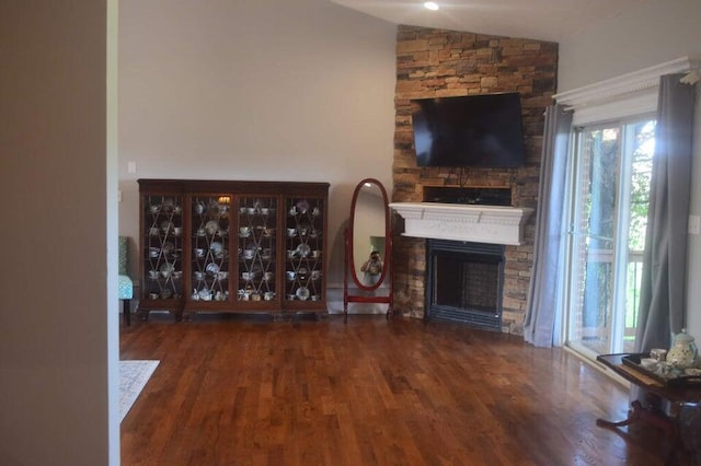 unfurnished living room with lofted ceiling, a fireplace, and dark hardwood / wood-style flooring