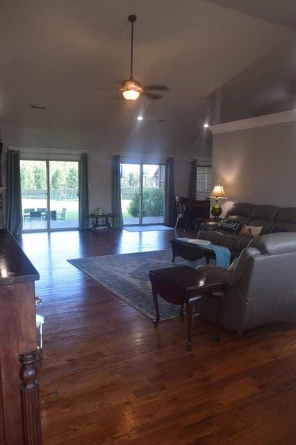 living room featuring dark hardwood / wood-style flooring, lofted ceiling, plenty of natural light, and ceiling fan