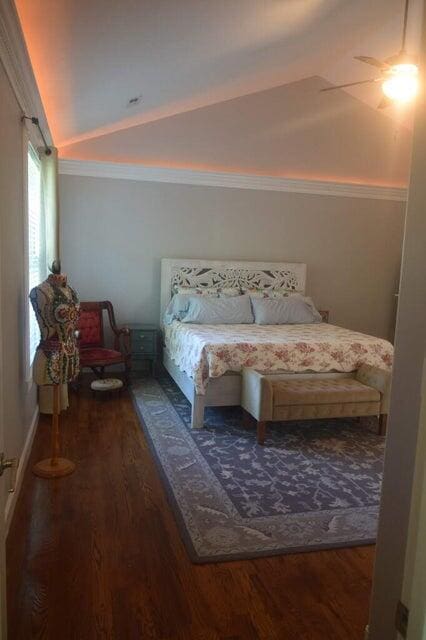 bedroom featuring crown molding, vaulted ceiling, hardwood / wood-style flooring, and ceiling fan