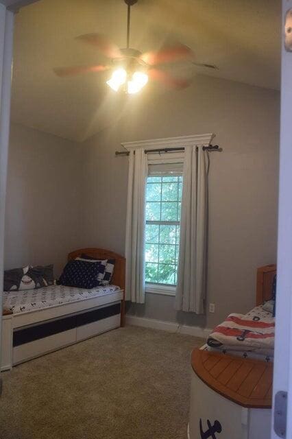 bedroom with vaulted ceiling, ceiling fan, and carpet floors