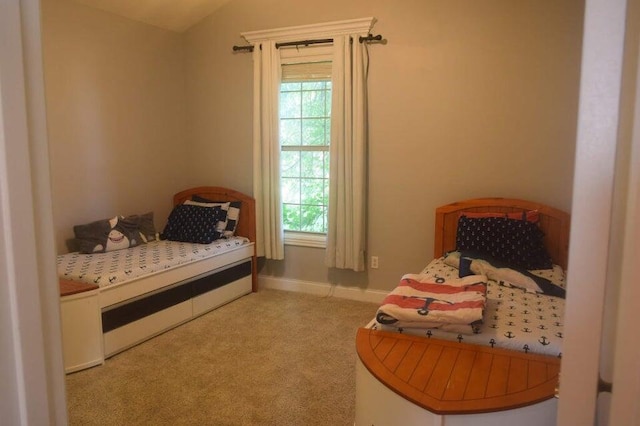 bedroom featuring lofted ceiling, multiple windows, and light carpet