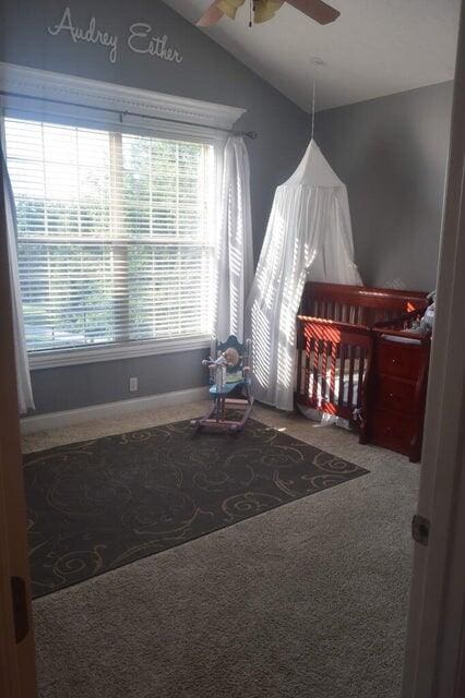 carpeted bedroom featuring ceiling fan and vaulted ceiling