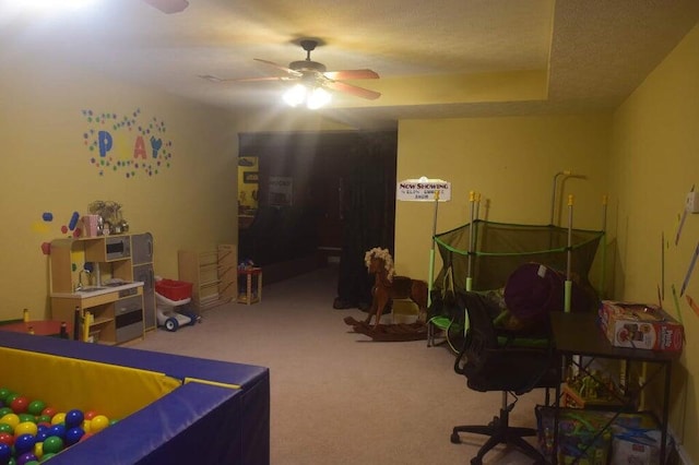 interior space featuring a textured ceiling, ceiling fan, and carpet floors