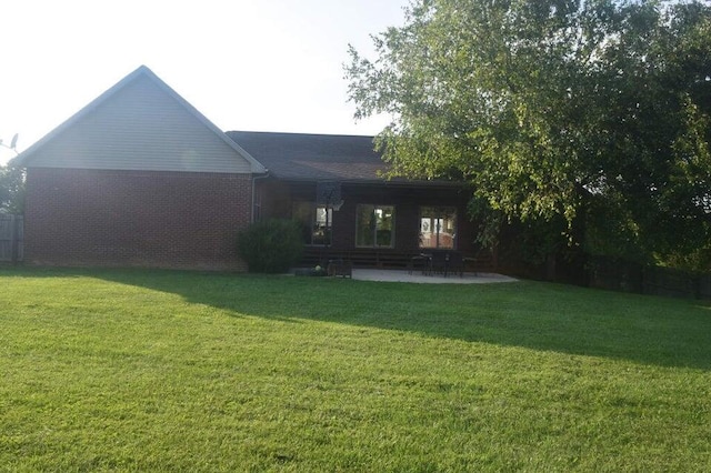 back of property featuring a patio area and a lawn