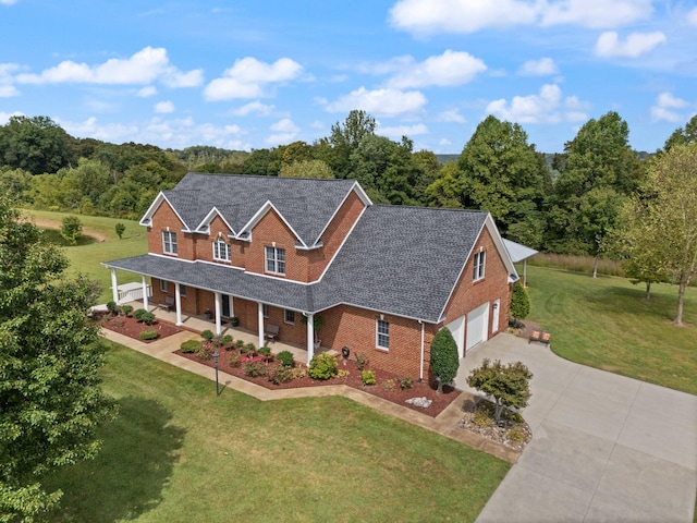 view of front of home featuring a garage, covered porch, and a front yard