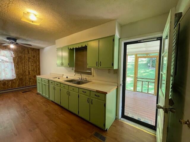 kitchen with a textured ceiling, ceiling fan, sink, and green cabinets