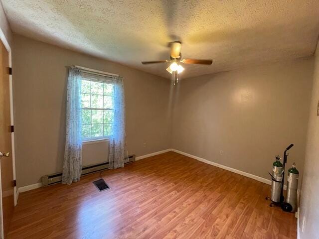 spare room with a textured ceiling, hardwood / wood-style floors, and ceiling fan