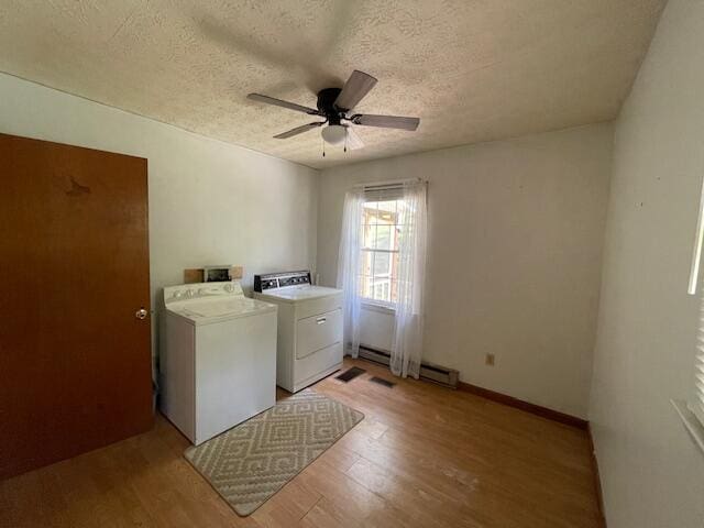 clothes washing area with light wood-type flooring, a textured ceiling, washing machine and clothes dryer, and ceiling fan