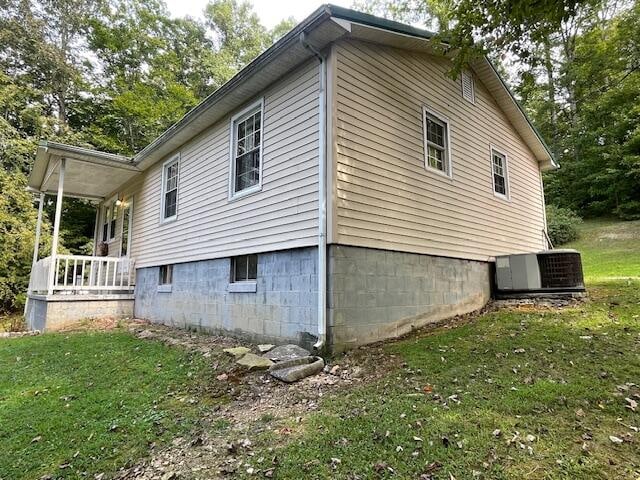 view of side of home with central air condition unit and a yard