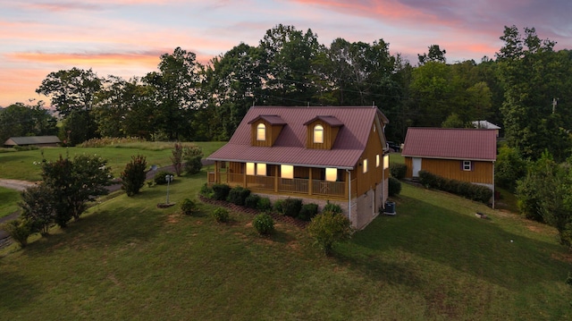 view of front facade featuring a lawn, central AC, and covered porch