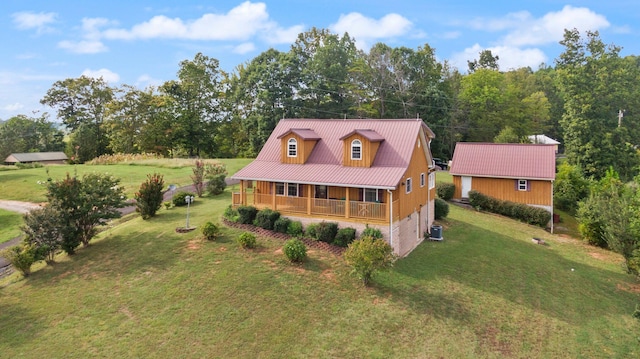 exterior space featuring central AC, a porch, metal roof, and a front yard