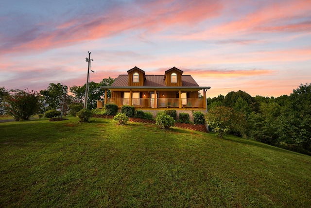 view of front of home with covered porch and a lawn