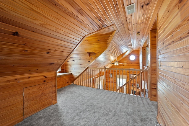 additional living space featuring visible vents, wooden walls, wood ceiling, and carpet