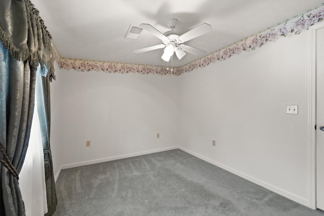 carpeted spare room featuring a ceiling fan and baseboards